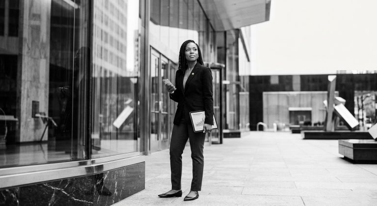 Real estate agent standing outside office building reflecting on what a brokerage is supposed to do for you and the role of support and systems in their business